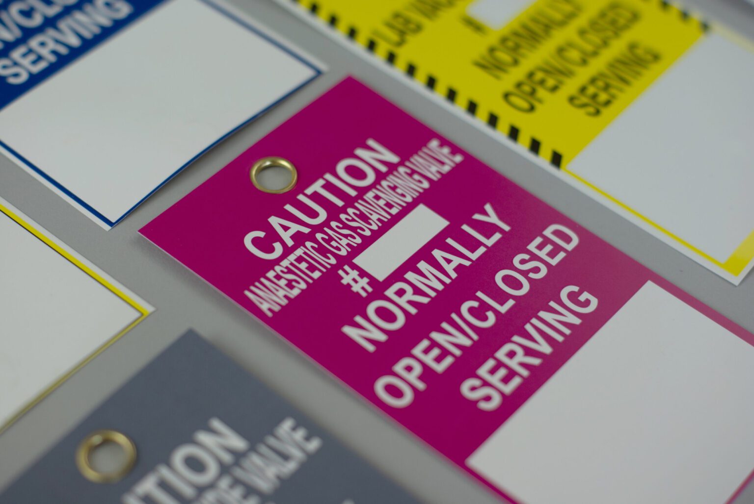 A close up of a red medical tag that reads "caution anesthetic gas Scavenging valve"