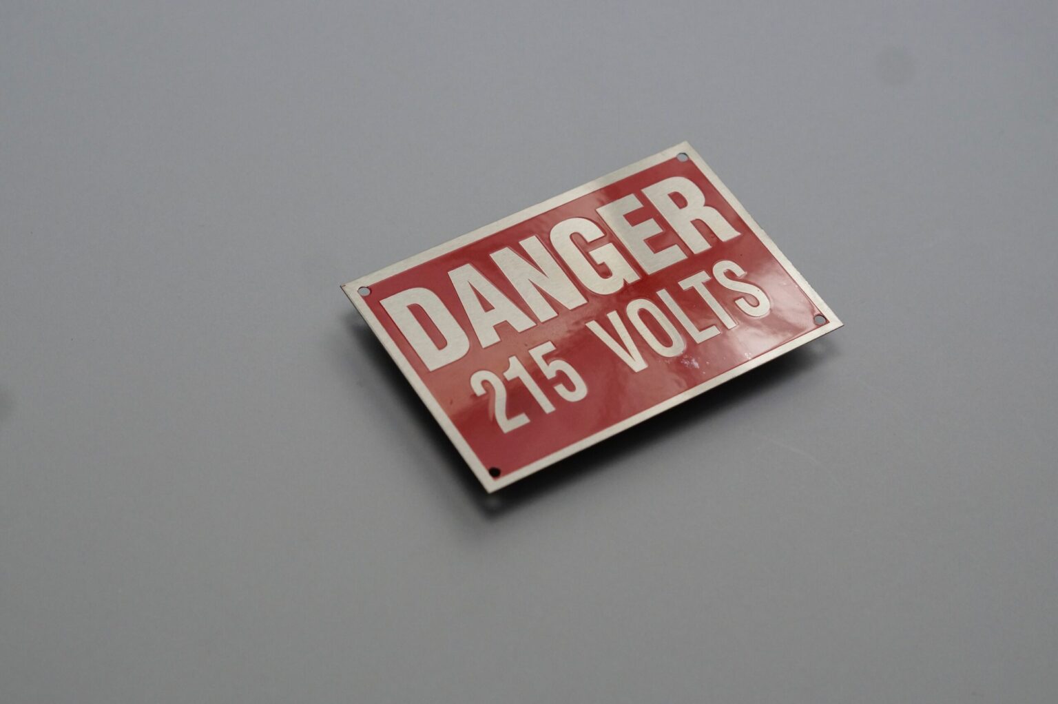 A red danger sign with white letters that reads "danger 215 volts"