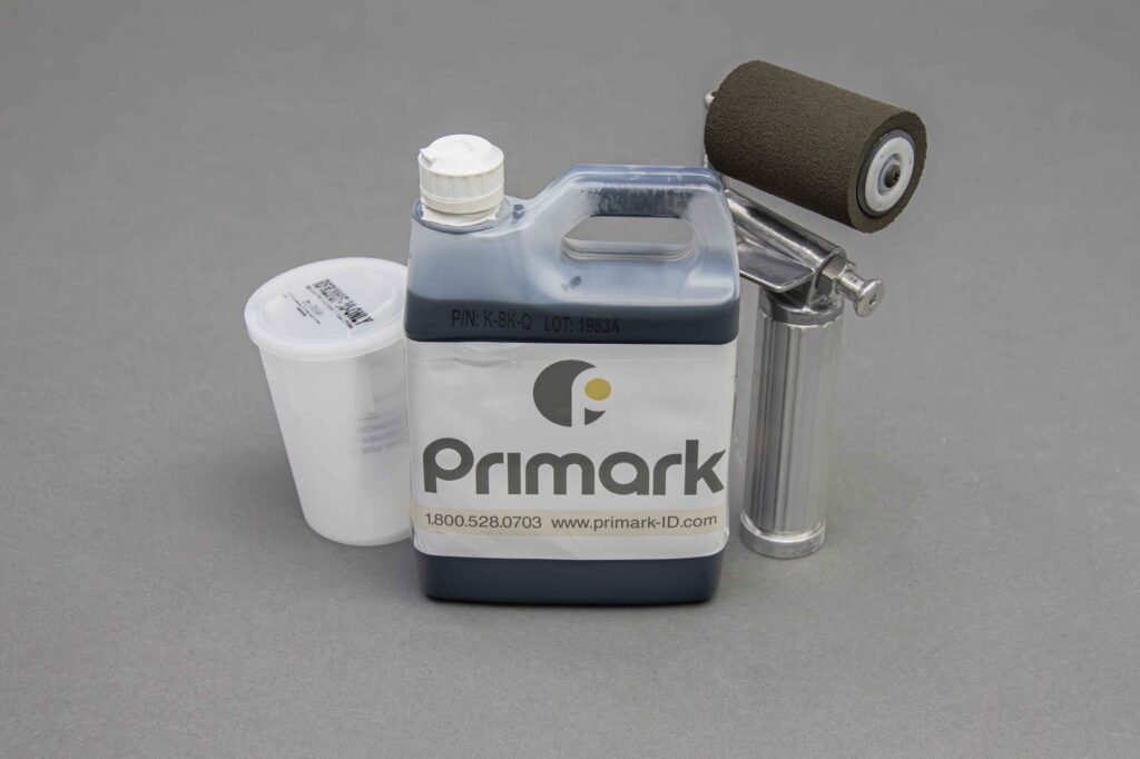 The mixer ink jug and ink roller are standing vertically nicely displayed in front of a clean gray background