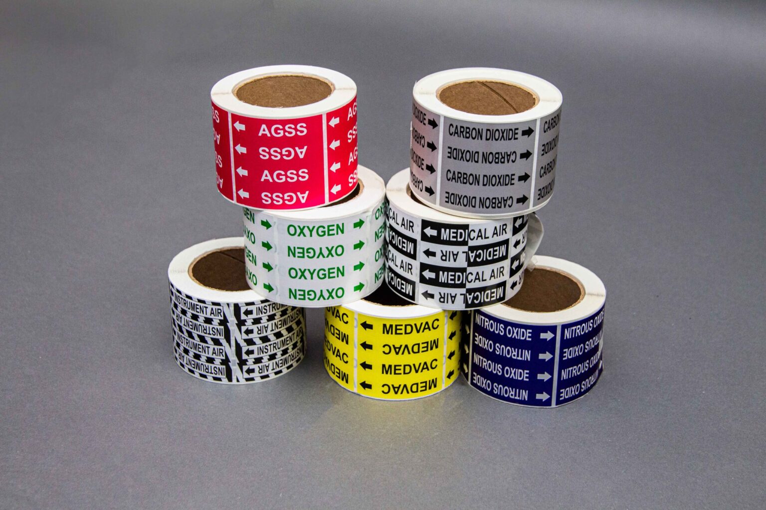 Black and white yellow and dark blue medical pipe labels hold up a stack of one white one black and white one gray and one red Medical pipe marker Sticker rolls