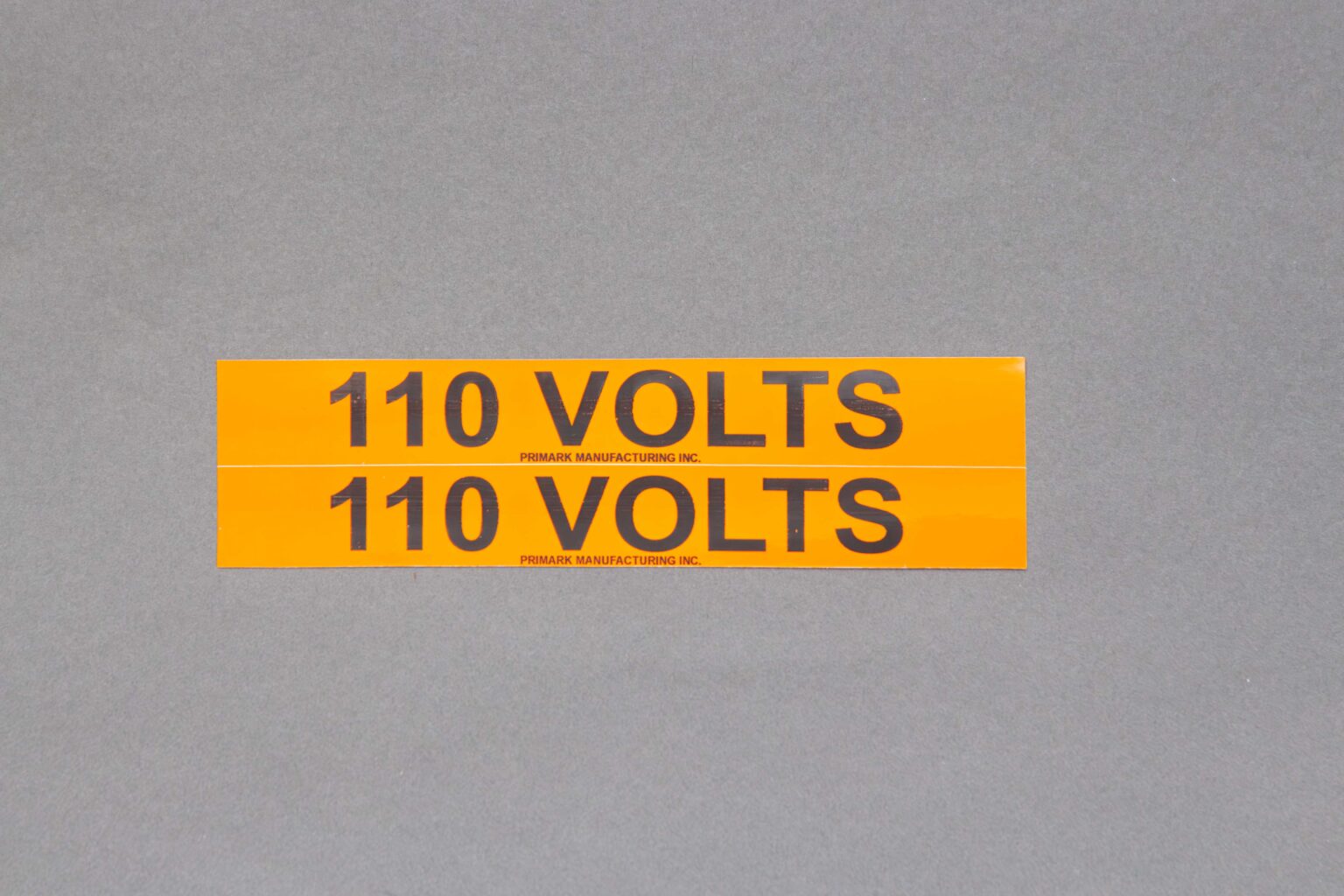An orange sticker that reads 110 volts in Black text