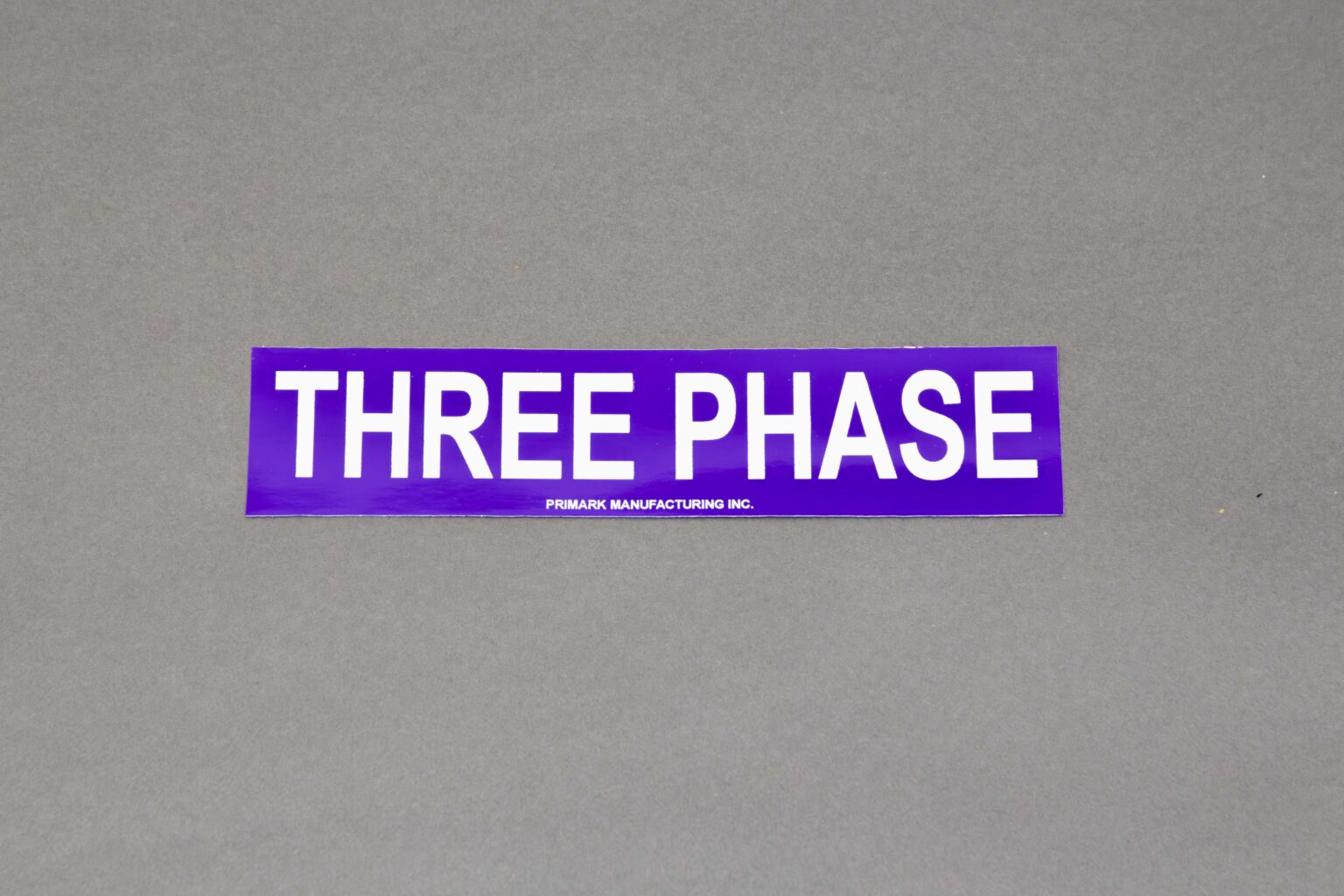 A purple adhesive conduit sticker that reads three phase in white text